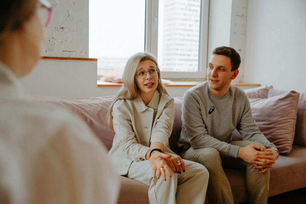 pexels-photo-3958379-3958379 A couple and therapist engaged in a discussion during a therapy session indoors.